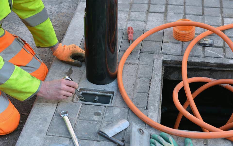 Man working on electrical components with an open access chamber