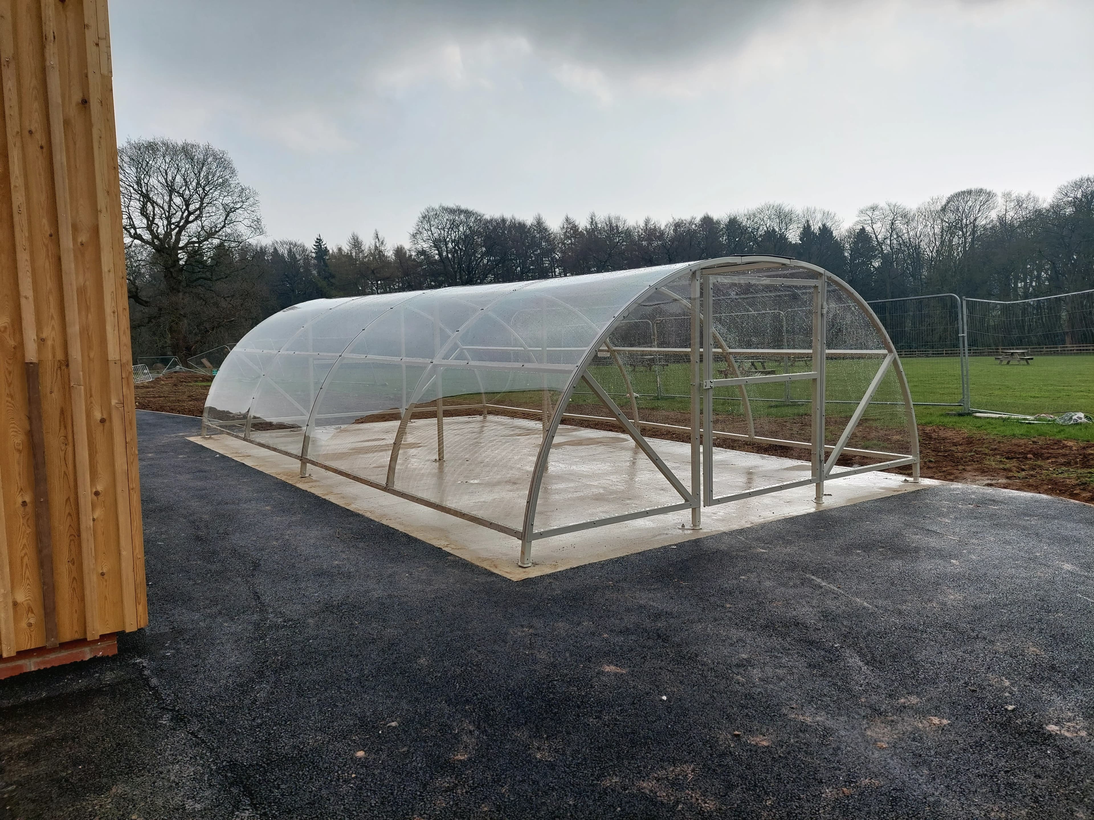 A compound large empty bike shelter near a football field